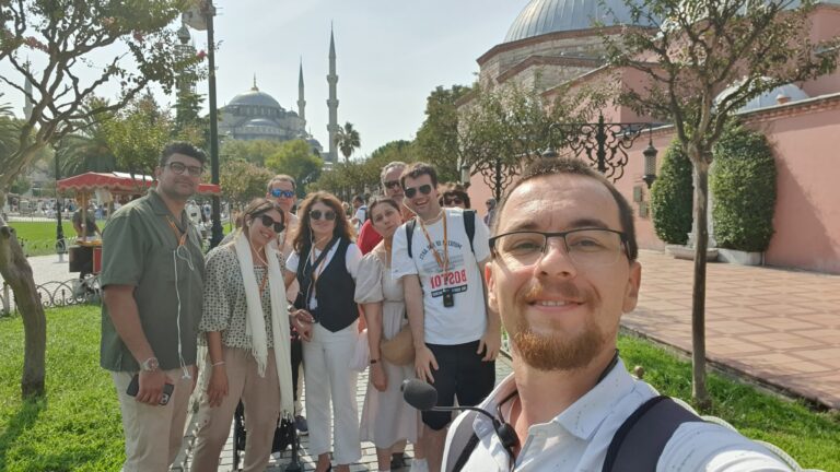 a man standing in front of a group of people posing for the camera
