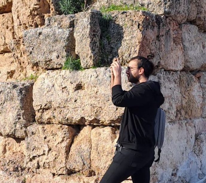 a person standing in front of a brick wall