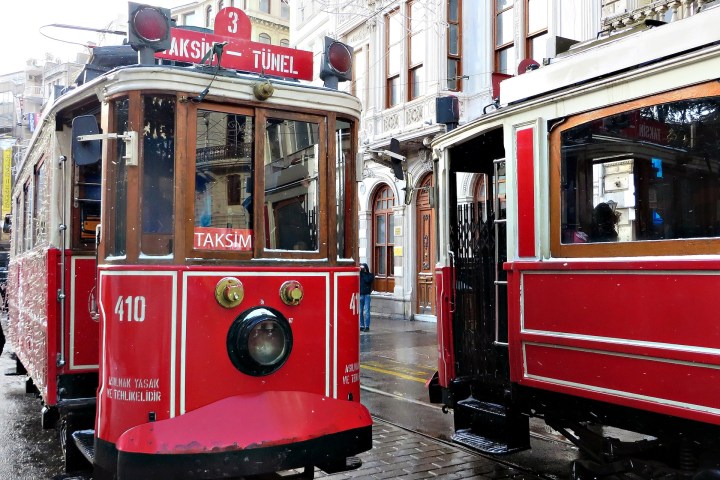 a red train is parked on the side of a building