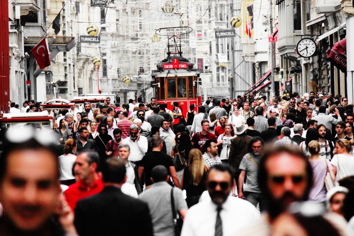 a group of people walking down the street in front of a crowd