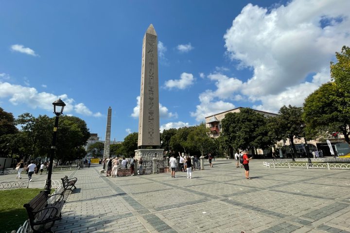 a group of people in a park with Place de la Concorde in the background
