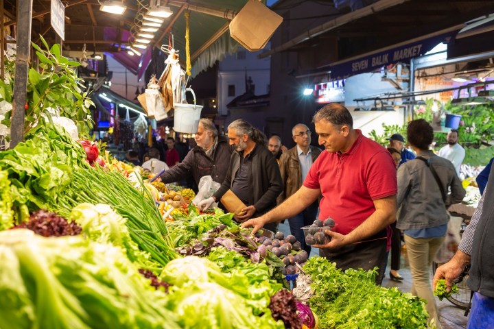 a group of people standing in front of a produce stand
