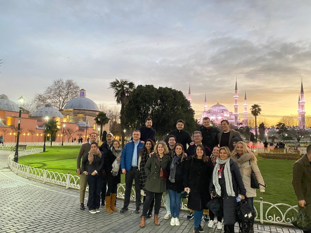 a group of people standing in front of a crowd posing for the camera