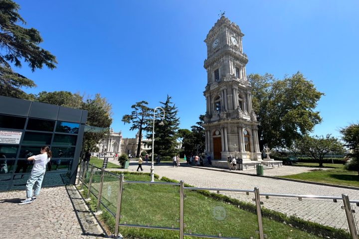 a clock tower in front of a fence