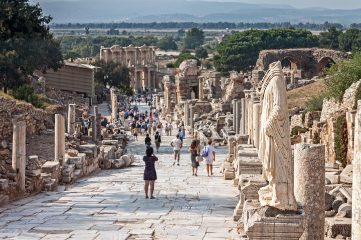 a group of people walking on a stone building
